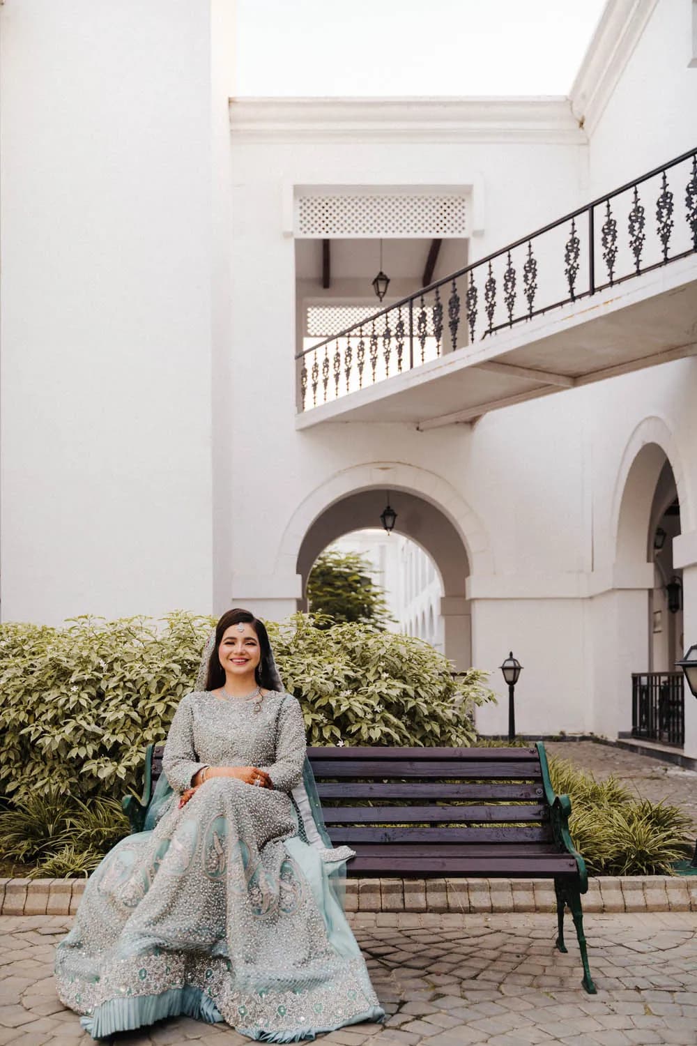 Bride seated in the courtyard of a white villa