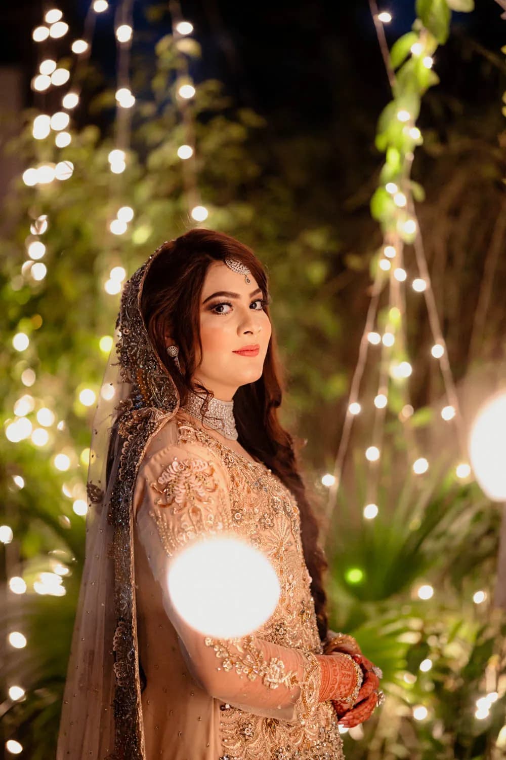 Bride under fairy lights at night