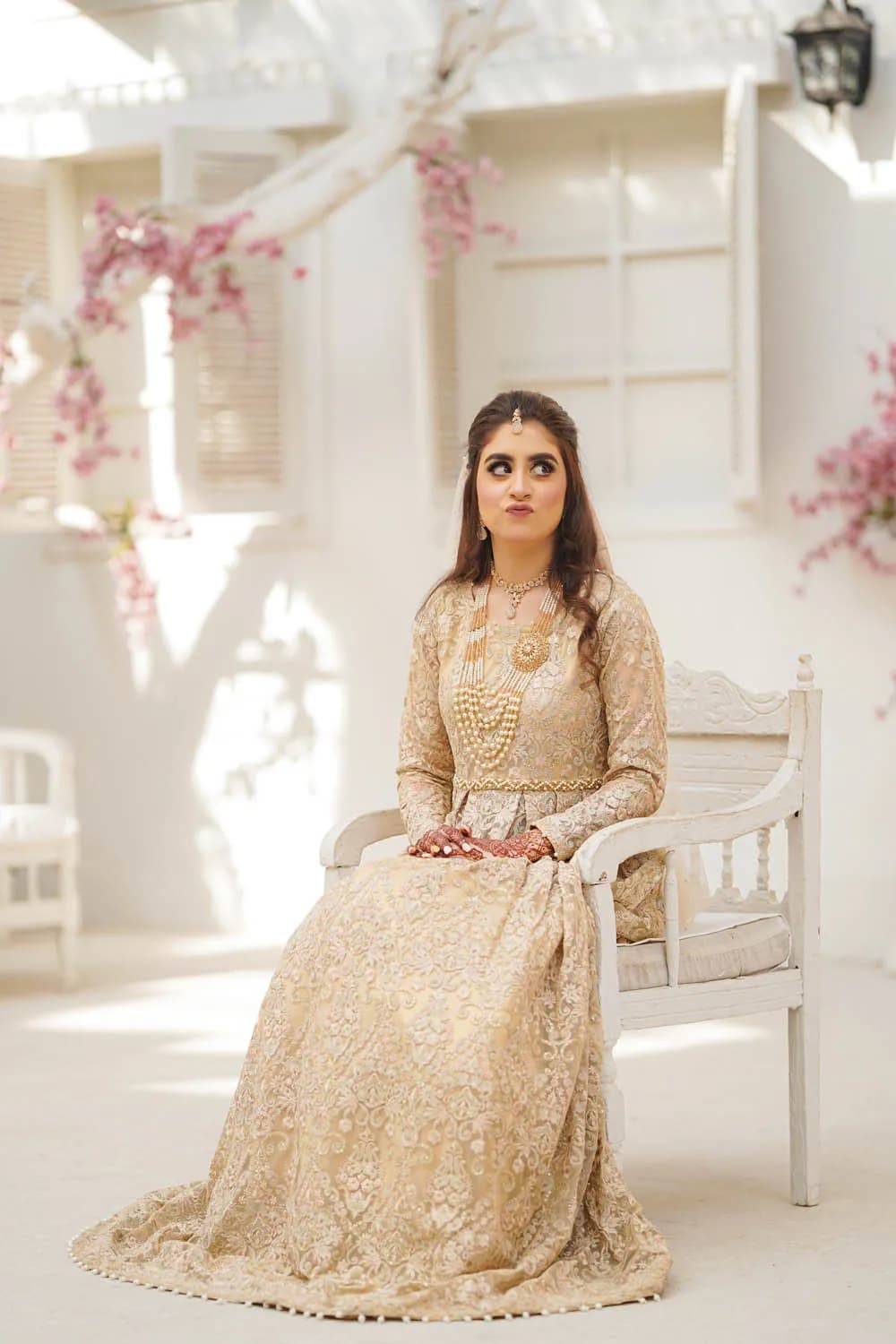 Bride seated in a white floral room