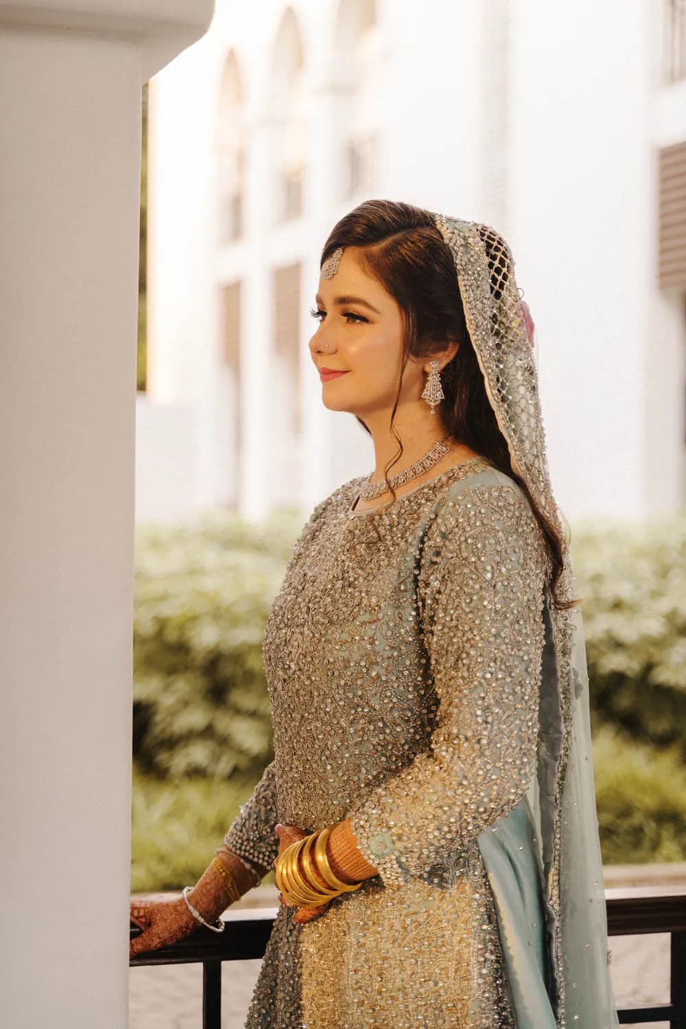 Bride in gold walking through a garden