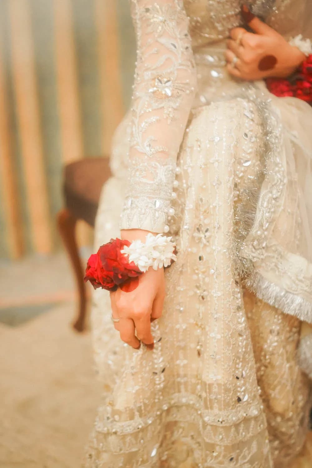 Detail of an embroidered ivory gown with red roses