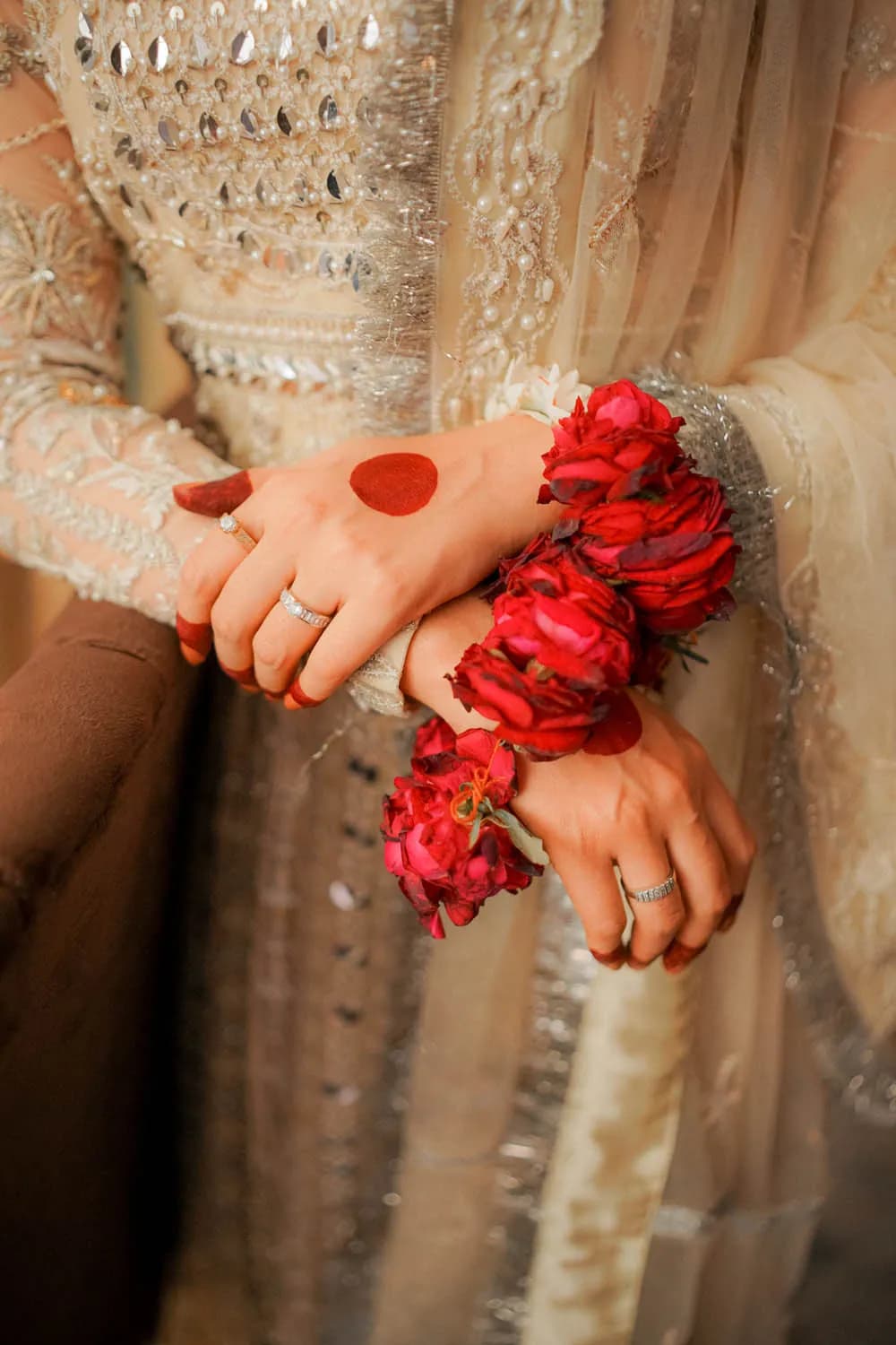 Close-up of the bride's hands with red rose bracelets