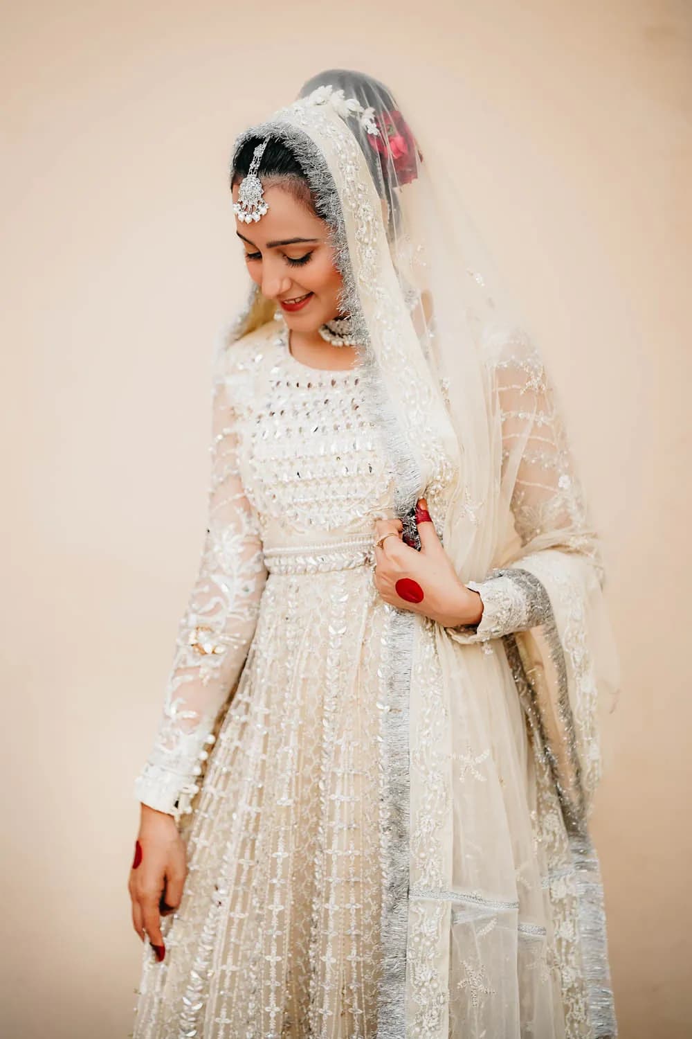 Bride in an ivory gown holding red roses