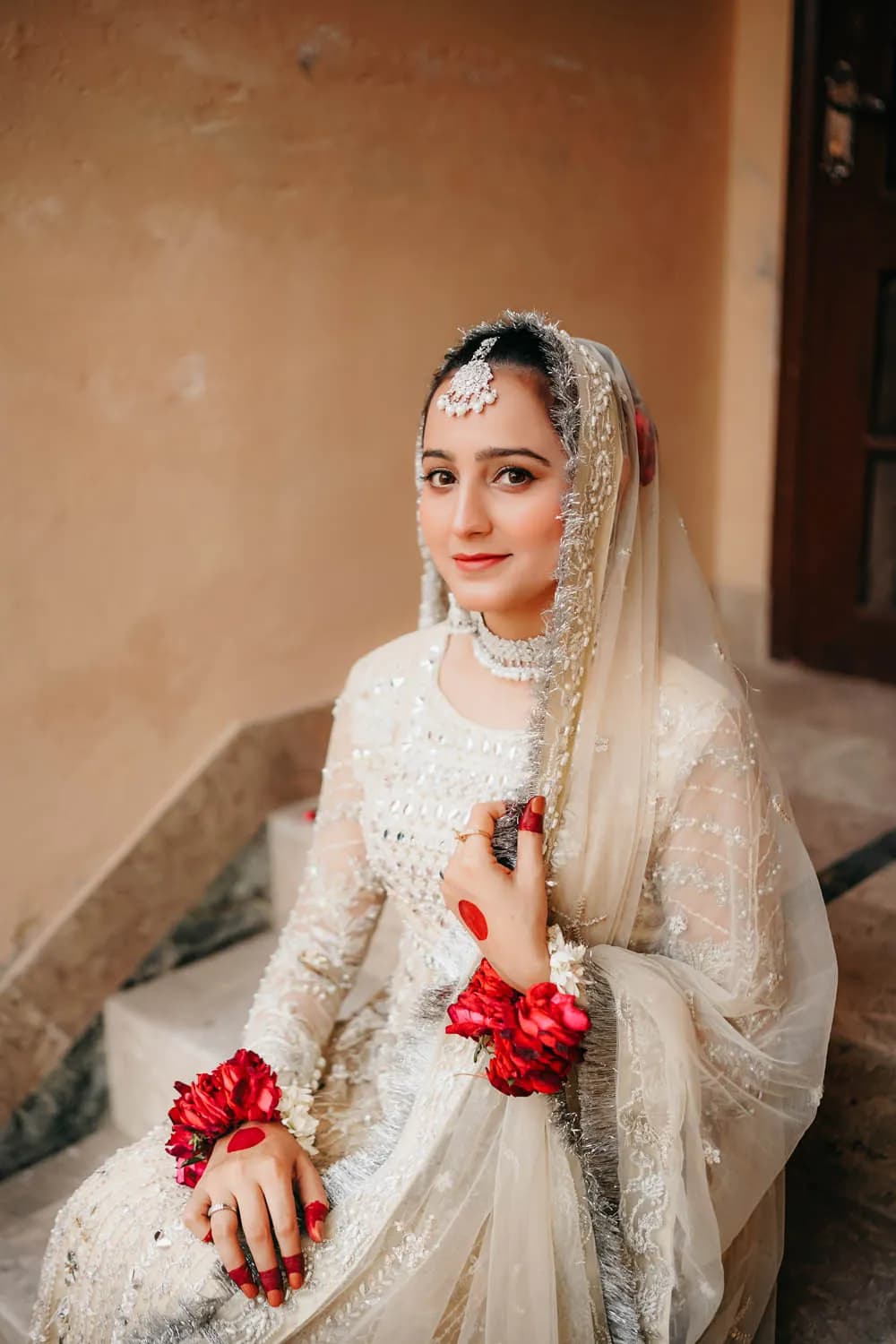 Bride seated with red roses