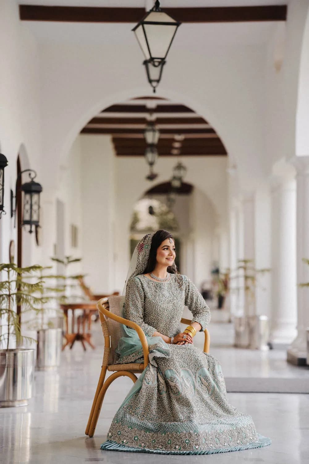 Bride seated in a long white arcade