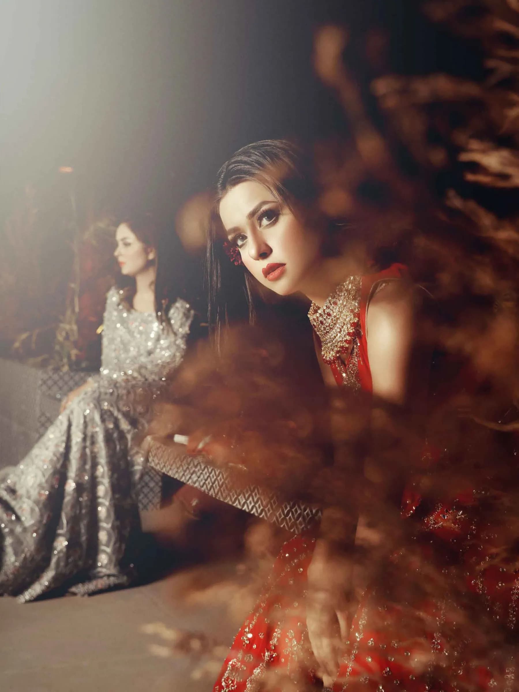 Model in a sequinned outfit seen through autumn foliage
