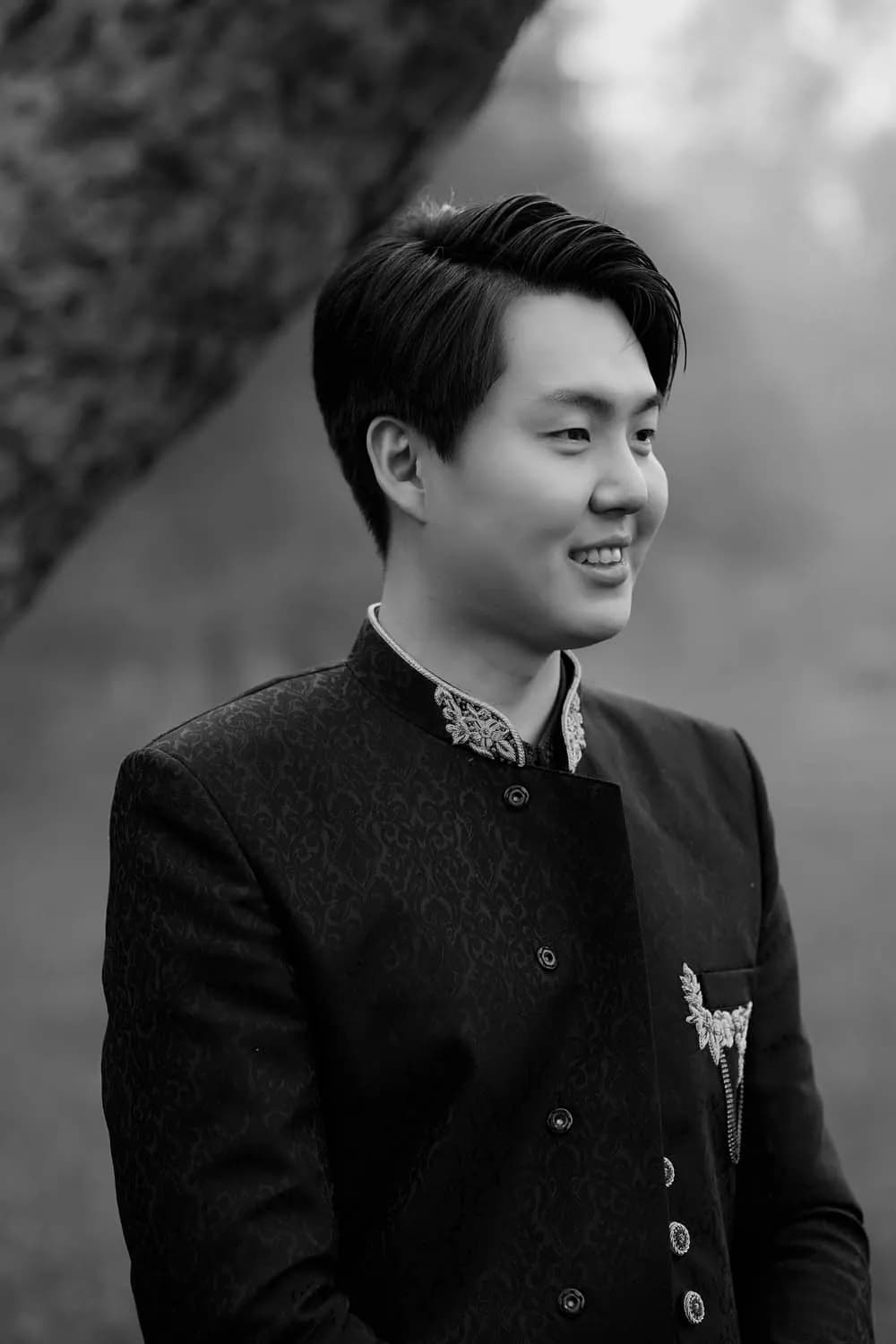 Black and white portrait of a smiling groom