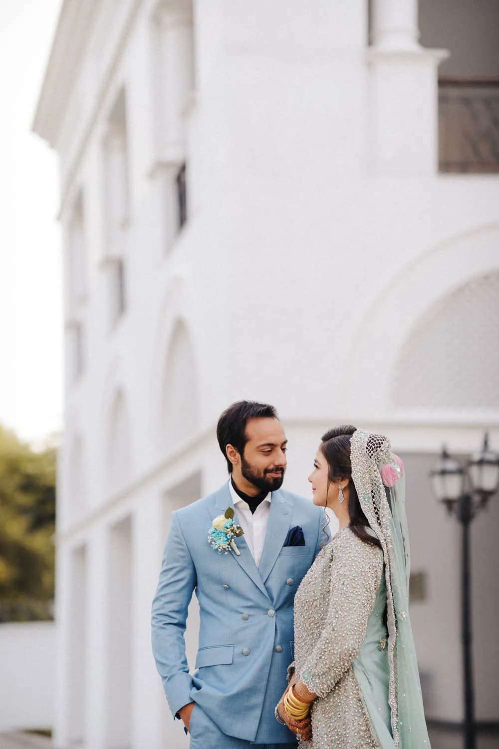 Couple in powder blue by a white colonial building