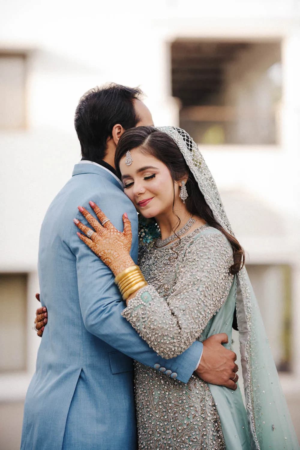 Groom embracing the bride, both in powder blue