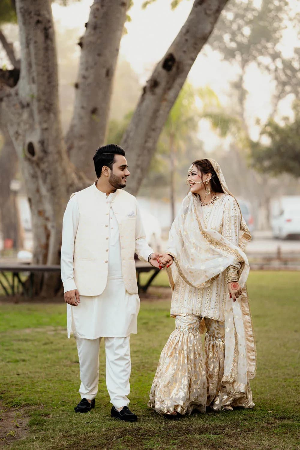 Couple walking through a garden in white outfits