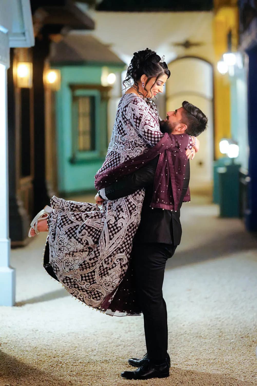 Groom lifting the bride in a lantern-lit street