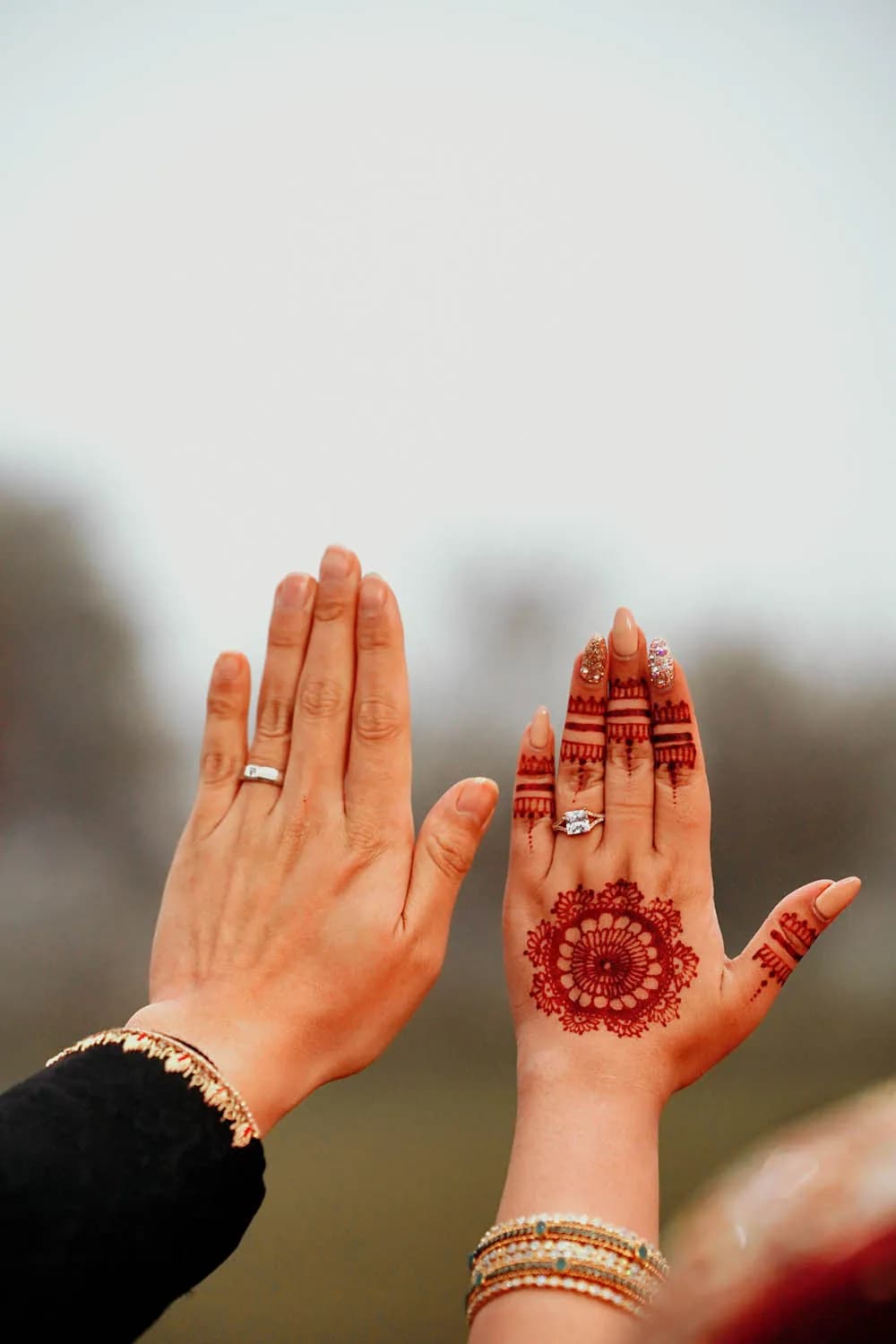 Henna-decorated hands of the bride and groom