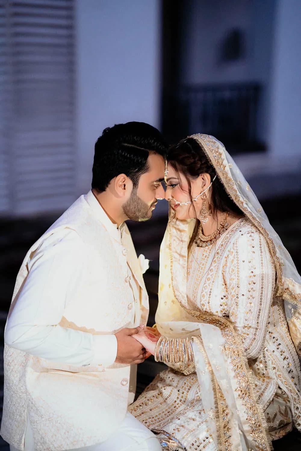 Couple sharing a tender moment in ivory outfits