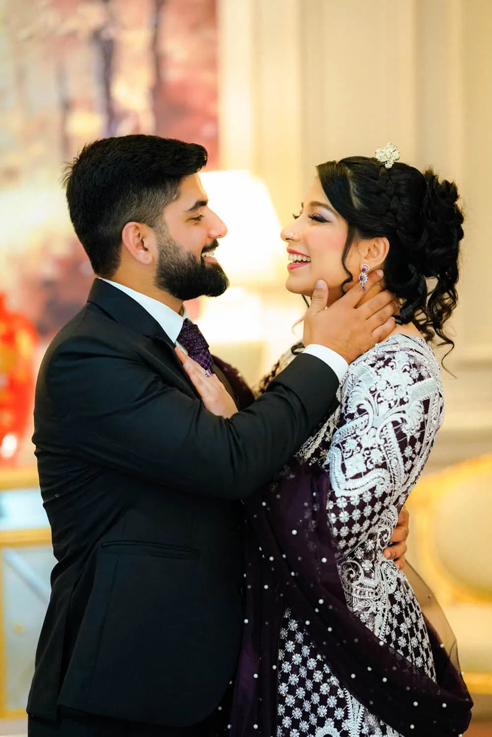 Groom and bride embracing in warm bokeh
